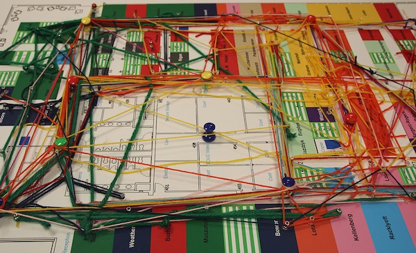 A network map made with yarn and push pins