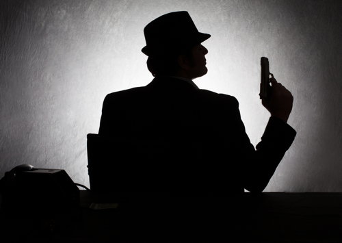 Photo silhouette of a mafia enforcer holding a handgun