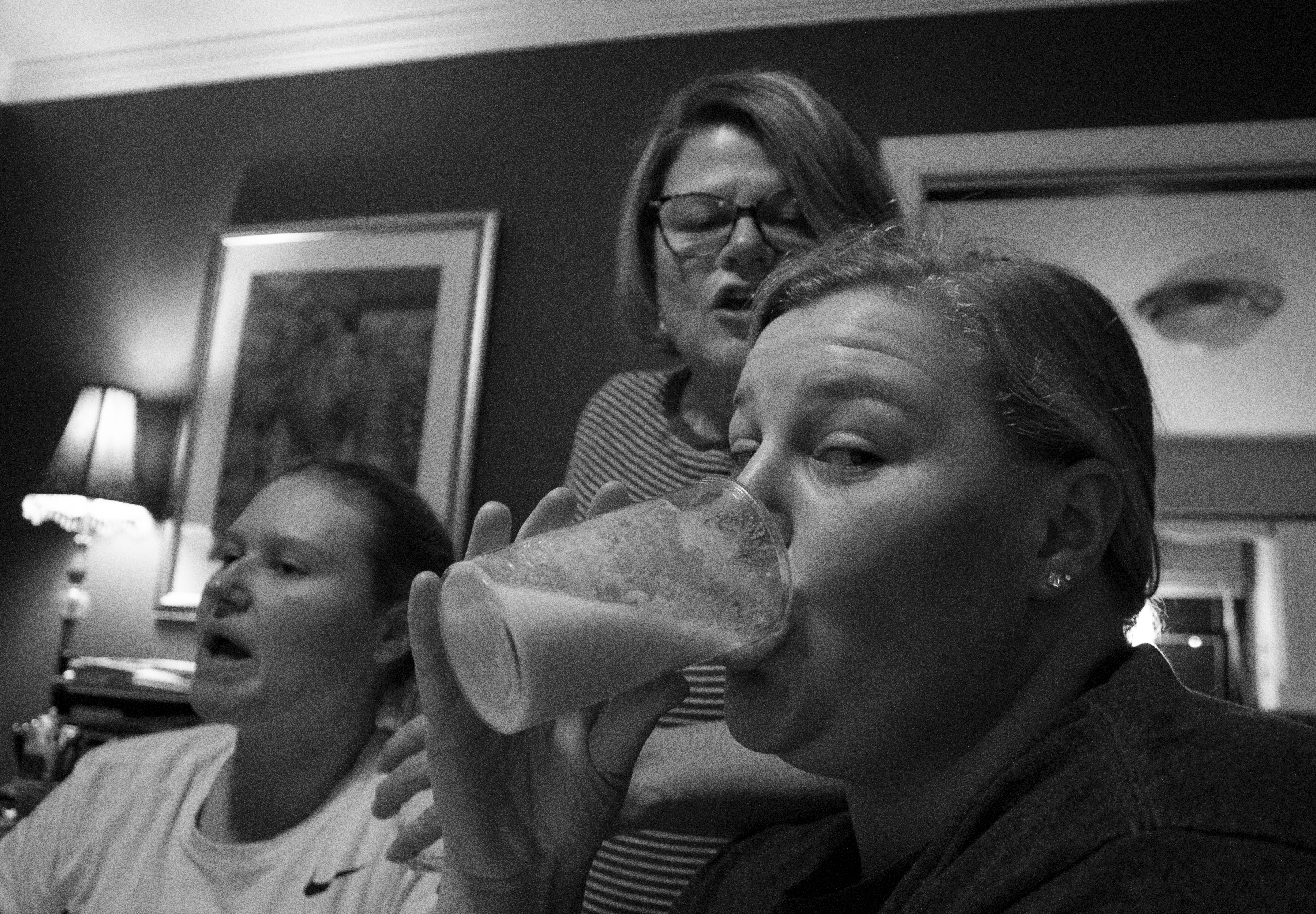 Avery Verlinde drinking milk while her mother and sister cause chaos.