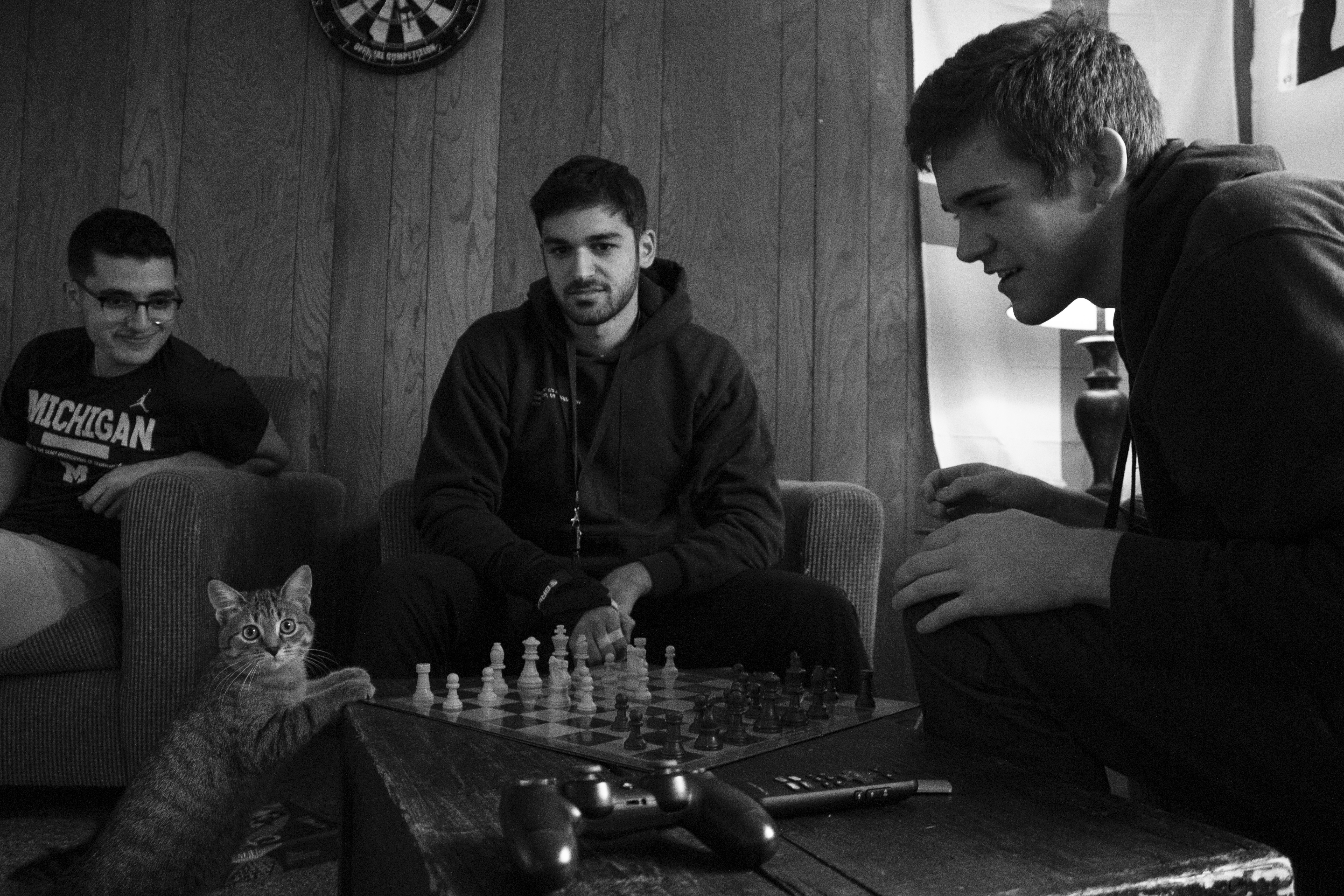 Grayson Buning Yousef Kobeissi and Christian Kassab watching Chani the cat try to play chess.